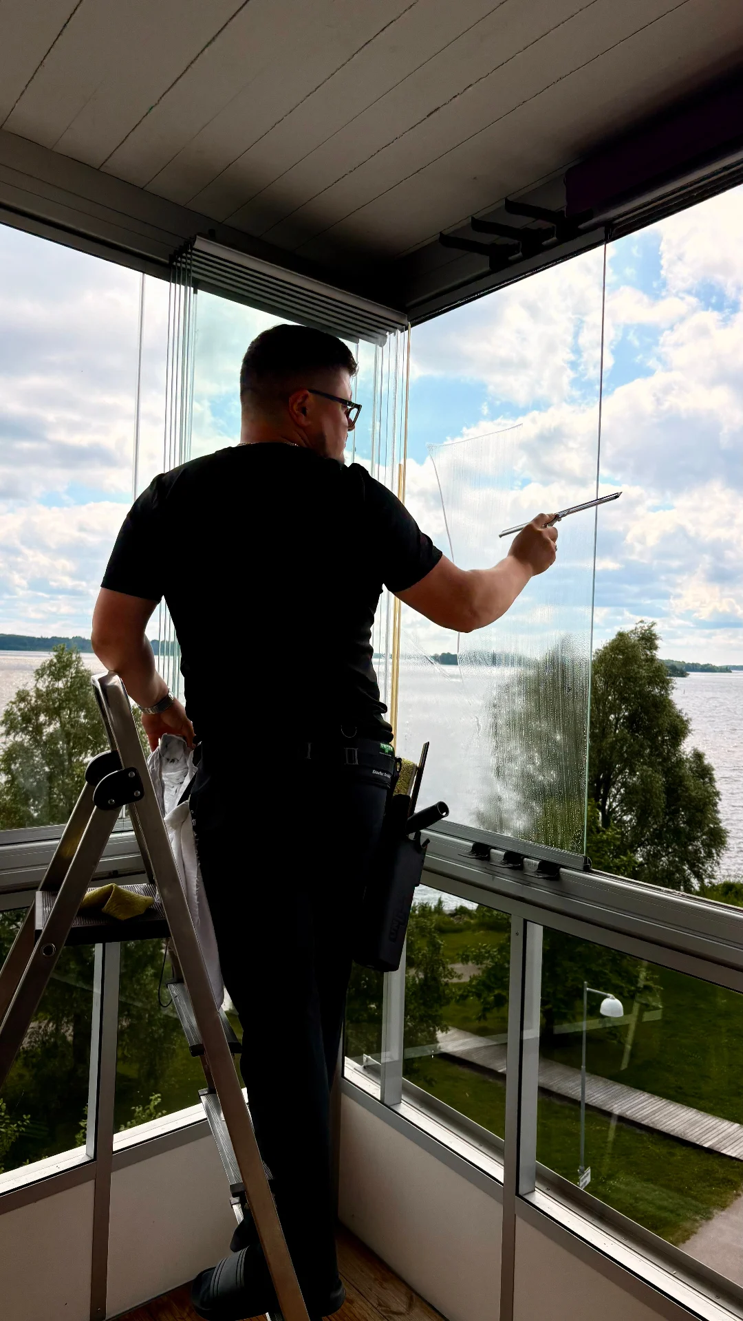 Medarbetare putsar fönster på balkong
